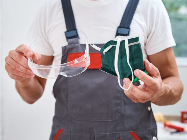 Renovation handyman with protective glasses and respirator, close up